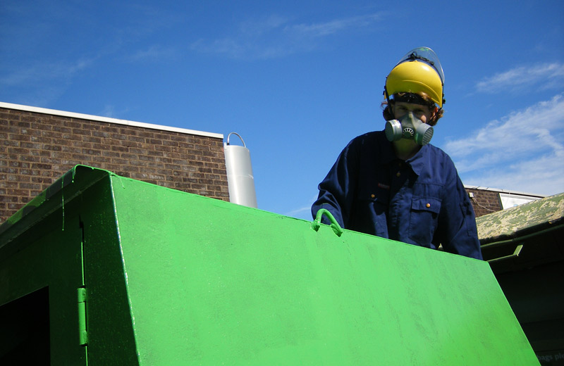 Painting a clothing bank outside the workshop
